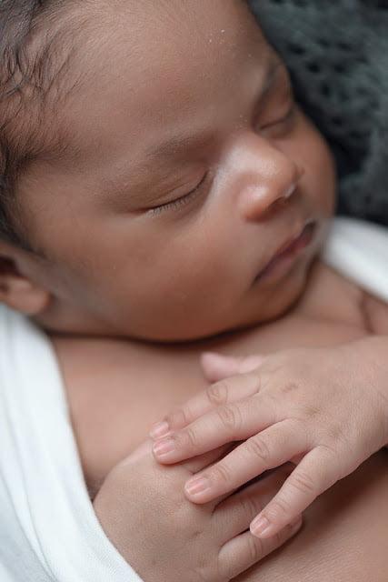 A mother cradling her newborn baby in her arms Baby's First Day Home: A Rollercoaster of Emotions